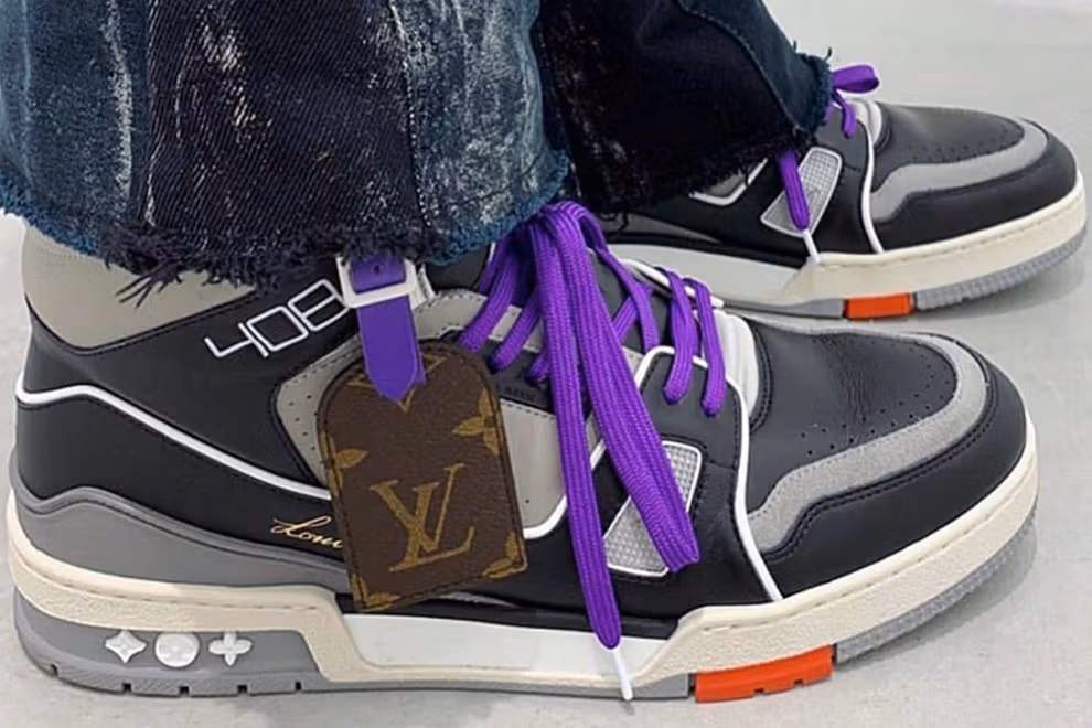 Close-up on-foot shot of Louis Vuitton LV Trainer 408 high-top sneakers in black and grey leather